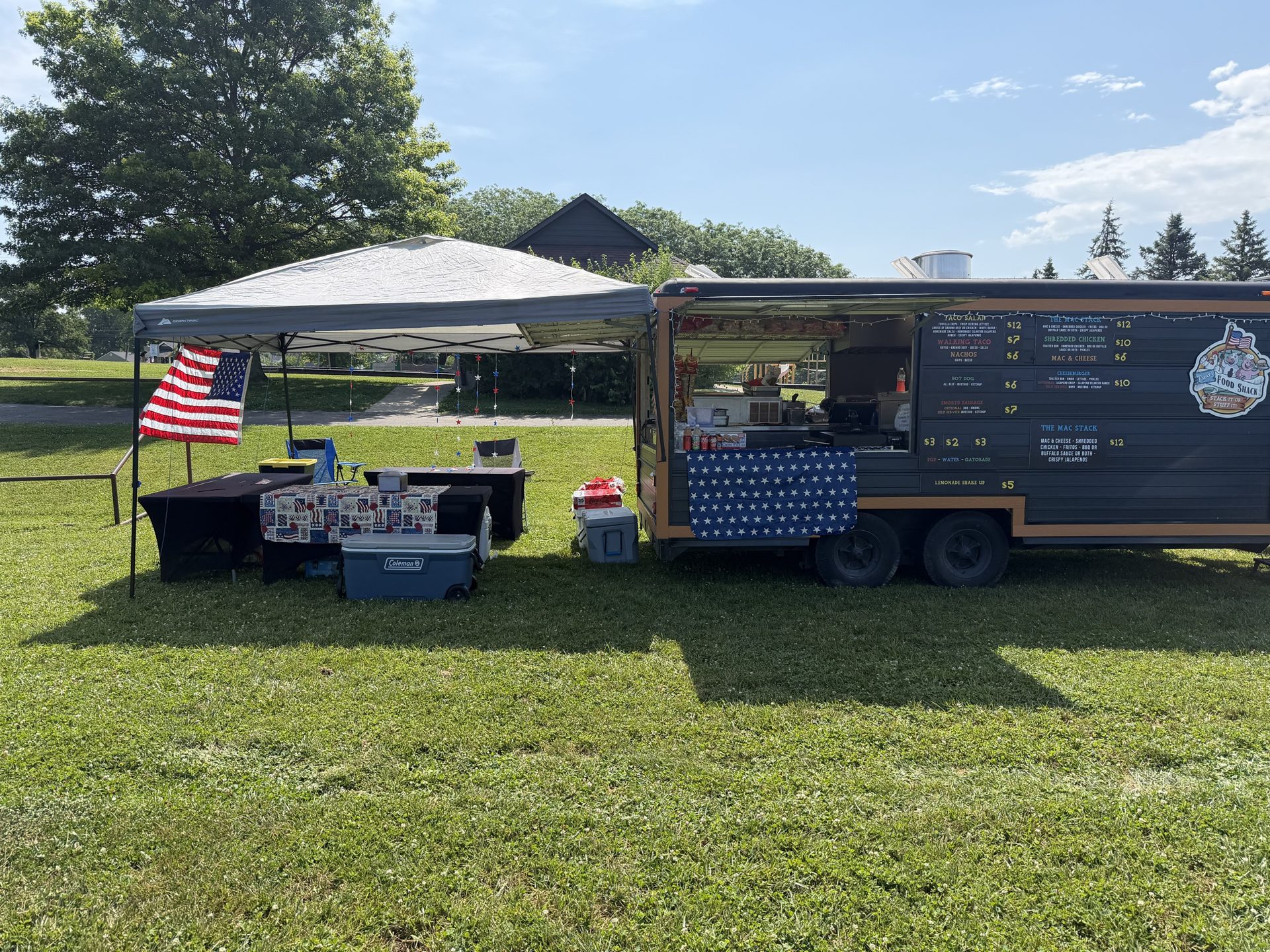 Trailer and tent set up beside an American flag